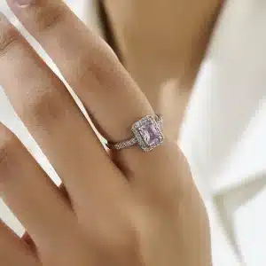 تصویری از یک حلقه نقره‌ای ظریف با نگین مستطیلی بنفش که با نگین‌های ریز درخشان احاطه شده است. این انگشتر زیبا برای استایل‌های رسمی و روزمره مناسب بوده و جلوه‌ای لوکس و مدرن به دستان شما می‌بخشد.